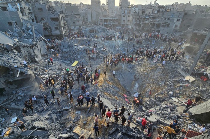Palestinians search for casualties at the site of Israeli strikes on houses in Jabalia